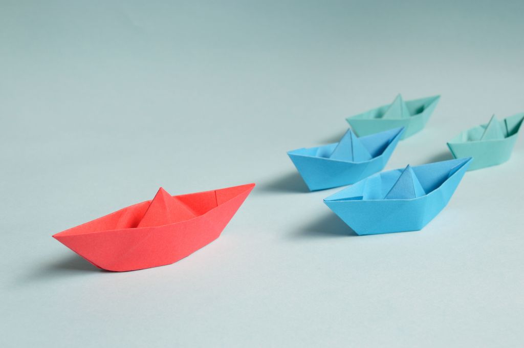 Colorful origami paper boats arranged to depict leadership and teamwork, credit Miguel A. Padrinan.